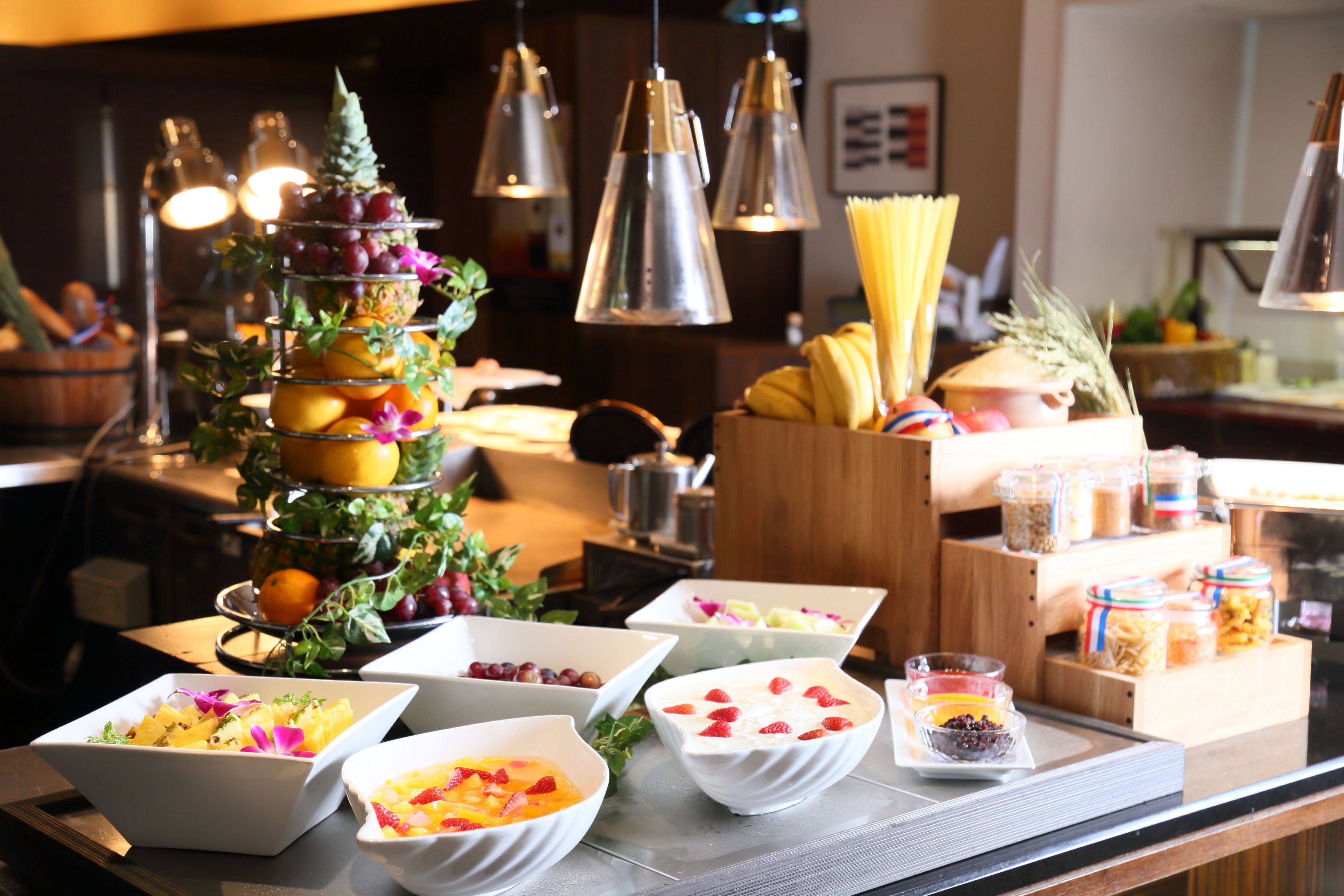 A buffet with various food items and a fruit display.