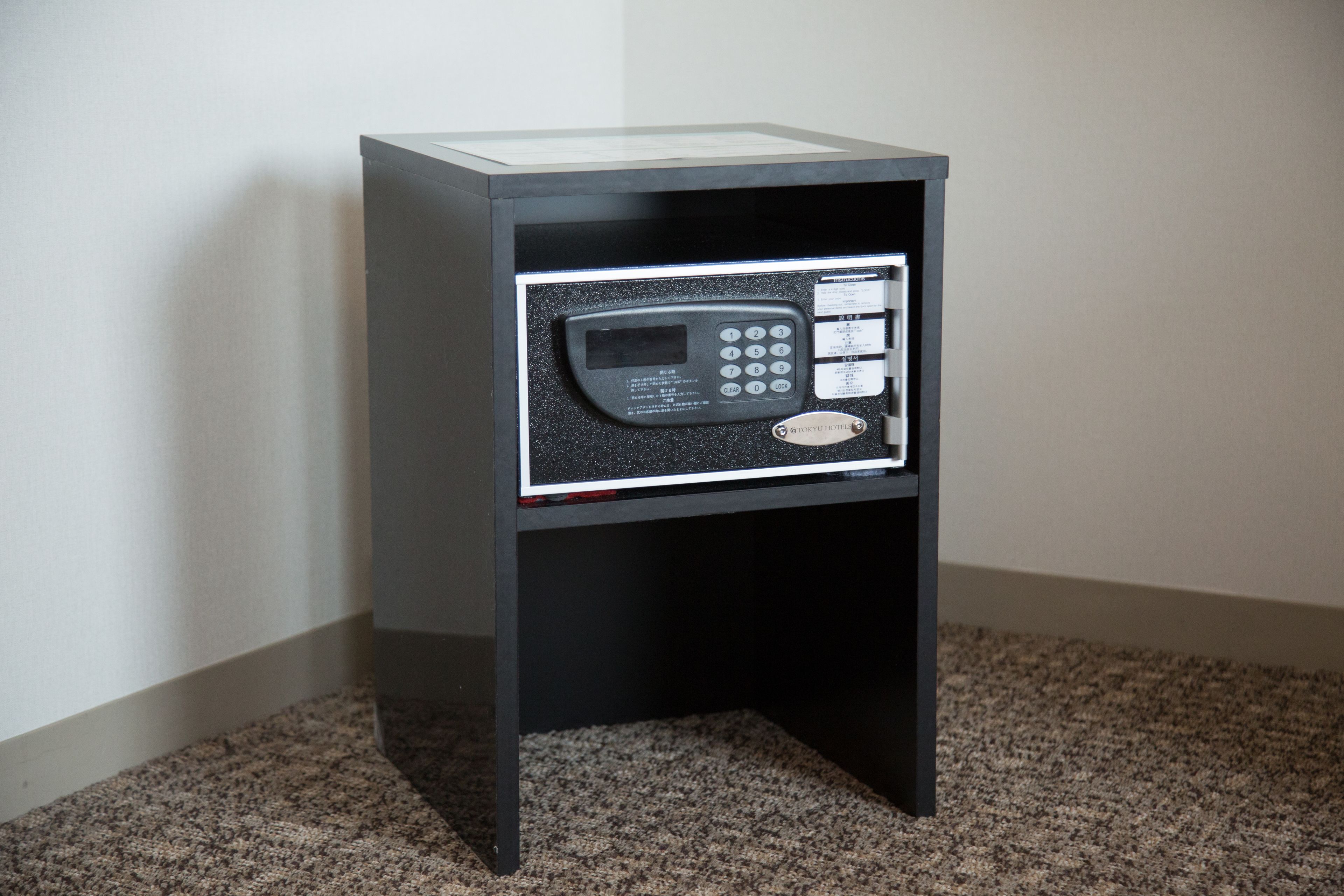 A small, black minibar with a digital control panel and a card reader.