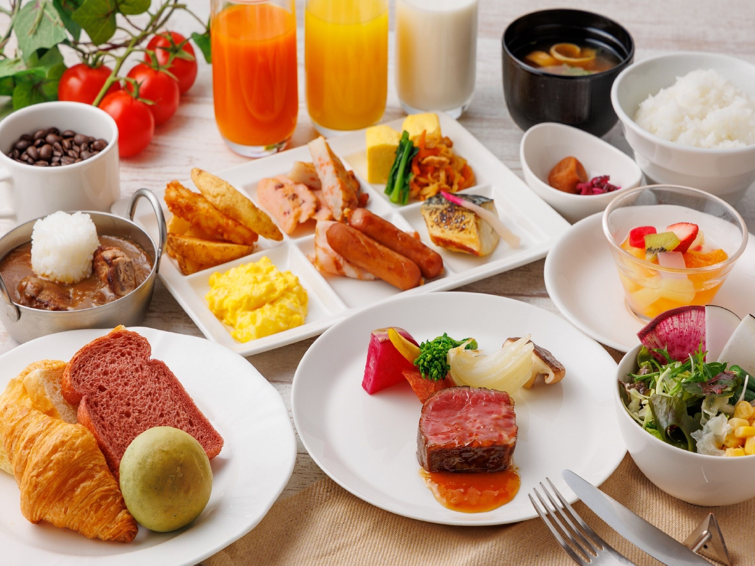 A breakfast buffet with various dishes including eggs, meats, and pastries.