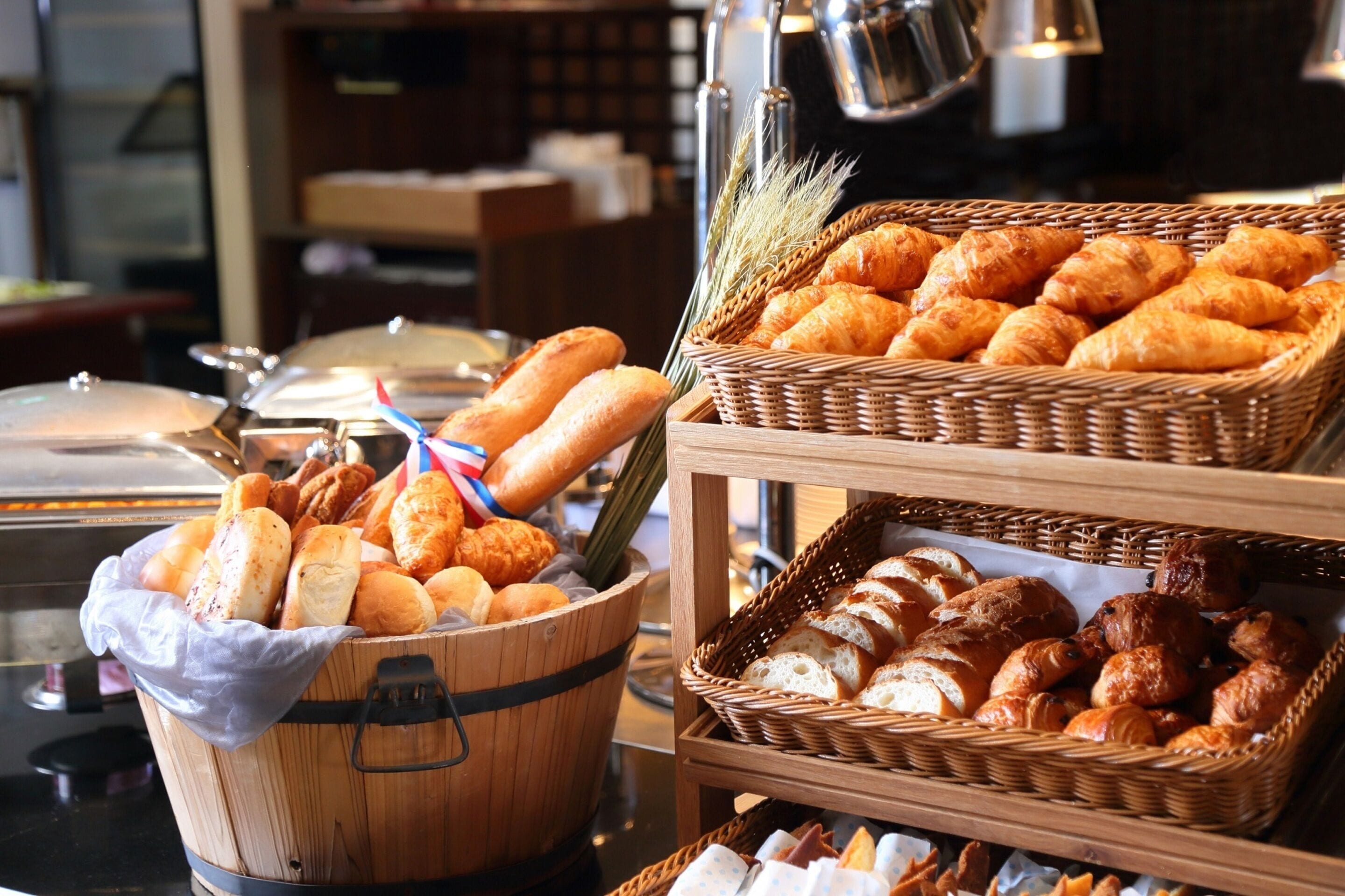 Un buffet proposant une variété de pains et de viennoiseries présentés dans des paniers.