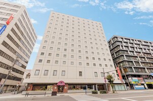 A multi-story hotel with a central entrance, large windows, and a flat facade.