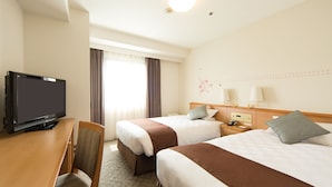 Une chambre d’hôtel avec deux lits, un bureau avec une télévision et une chaise.