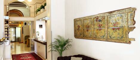 Un interior moderno con un sofá marrón, un tapete rojo y una pared decorada con azulejos.