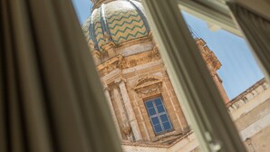 Vista a través de una ventana de un edificio con una gran cúpula y un marco azul.