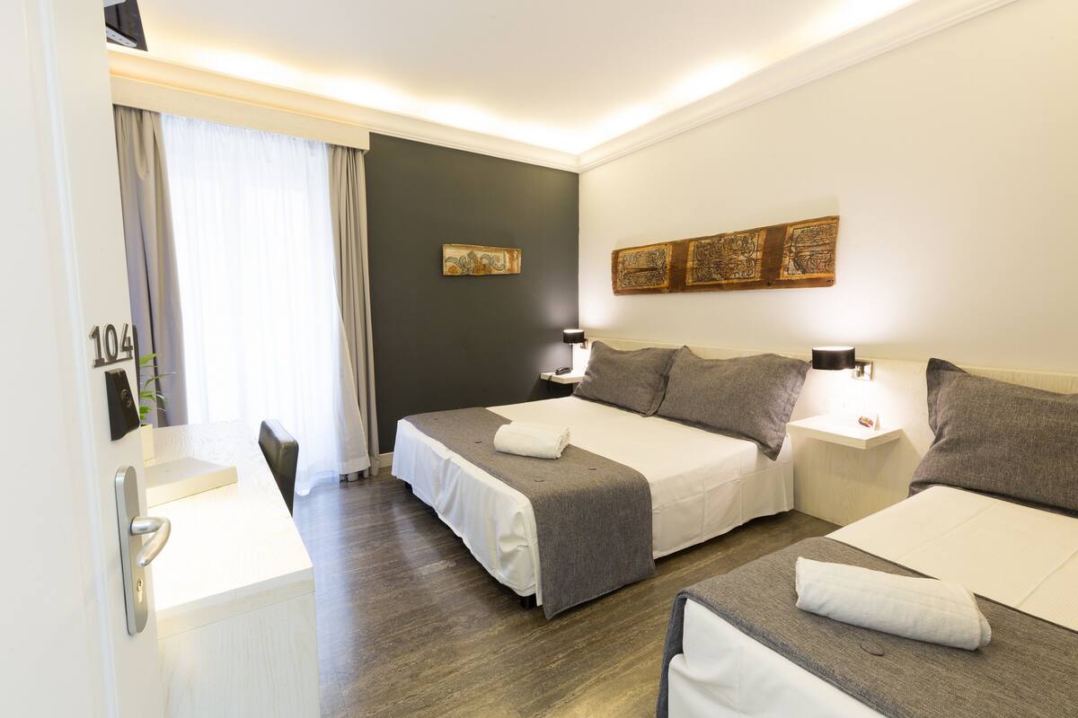 Une chambre d’hôtel avec deux lits, un bureau et une salle de bain.
