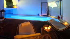 Zona de spa con piscina, sillas de descanso y velas.
