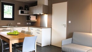 A compact living space with a kitchenette, a dining area, and a seating area.