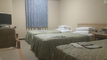A hotel room with two beds, a desk, a TV, and a window with curtains.