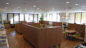 A modern restaurant with wooden booths and tables, large windows, and a clean, well-lit interior. - Narita U-City Hotel (Narita)