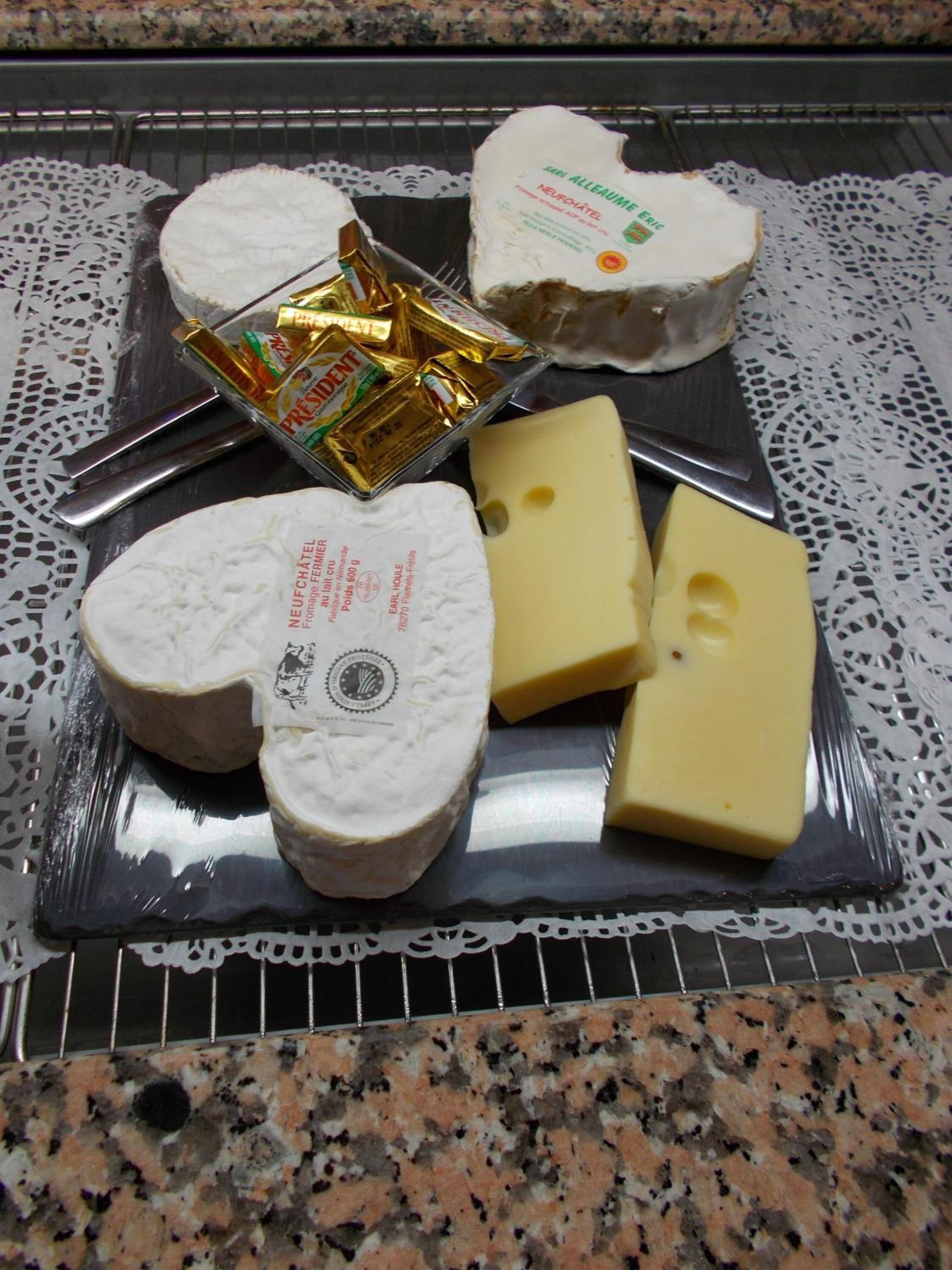 A variety of cheeses and chocolates on a tray.