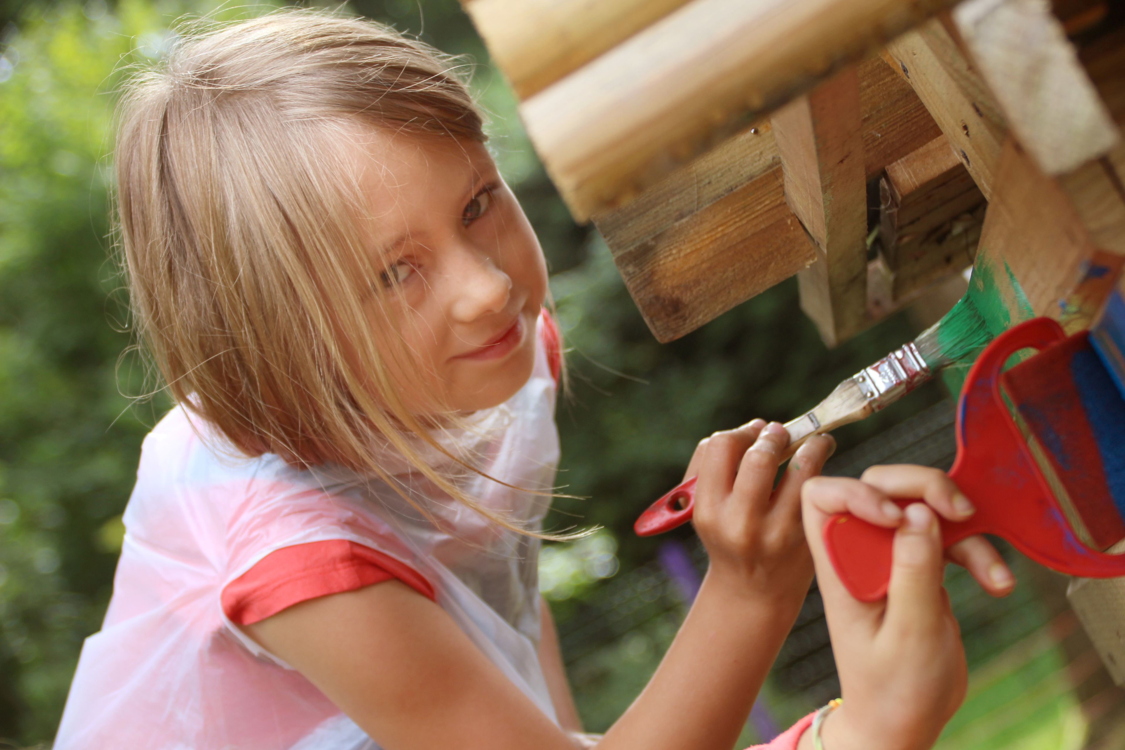 A person painting a wooden structure.