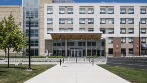 A modern building with a central entrance, multiple windows, and a flat roof. - Residence & Conference Centre - Ottawa West (Ottawa)