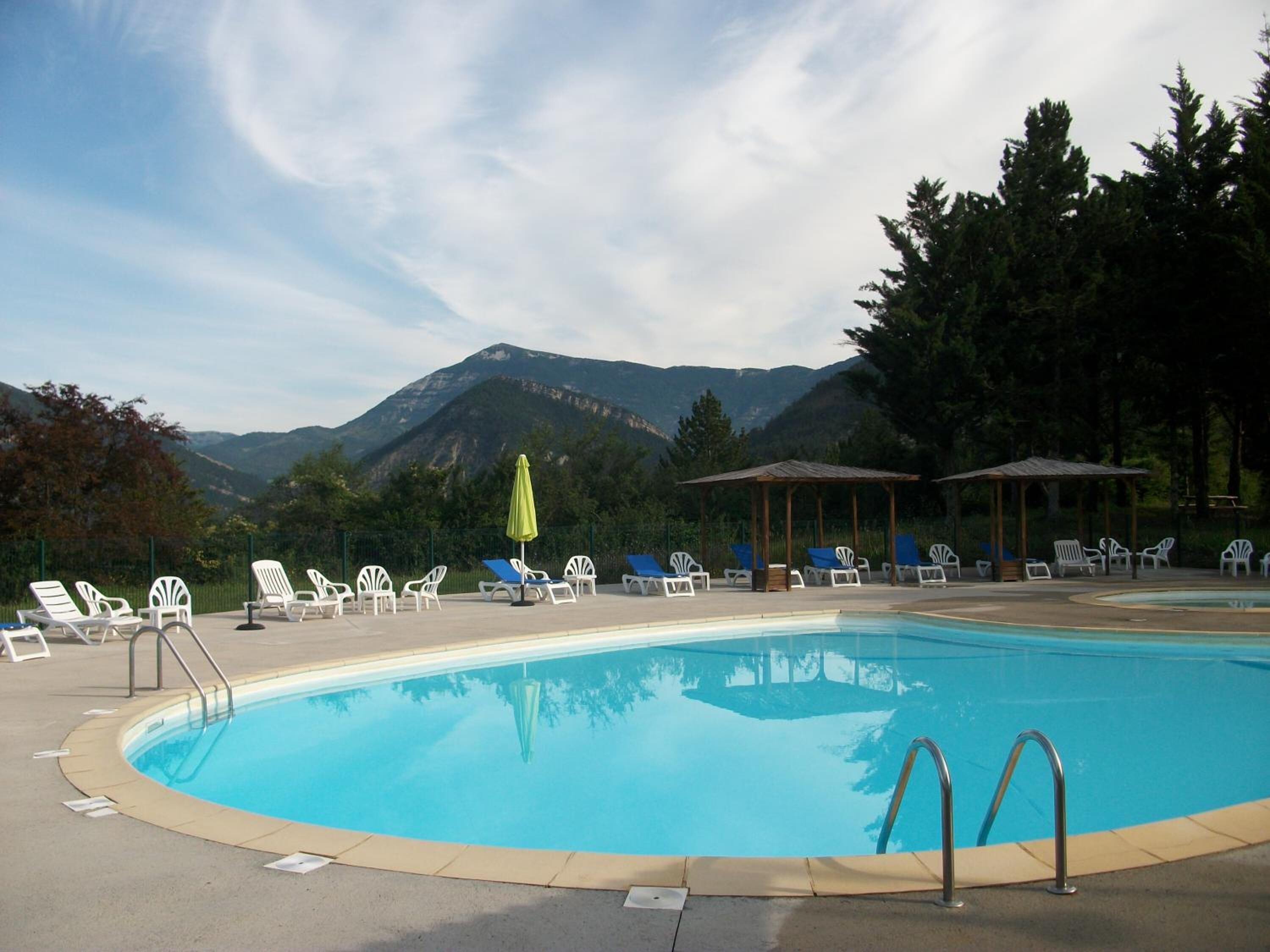 Een buitenzwembad en ligstoelen