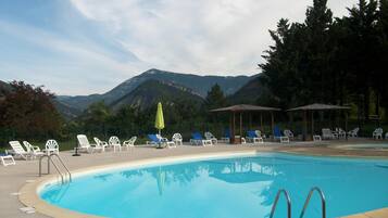 Een buitenzwembad en ligstoelen