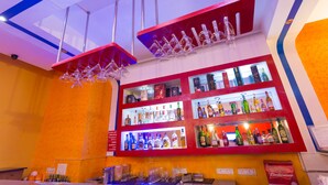 Un espace bar avec des étagères remplies de bouteilles d’alcool et de verres.