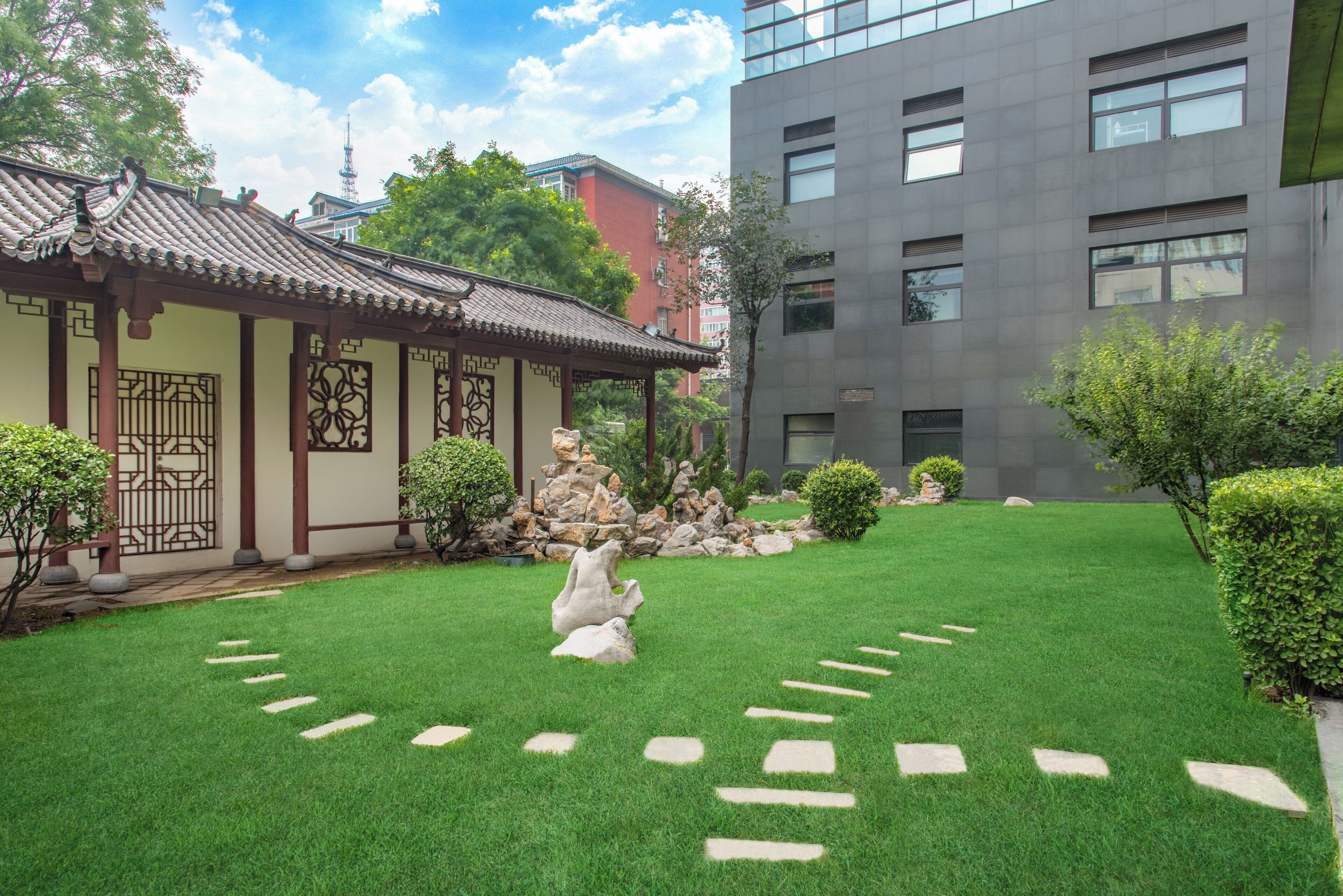 A traditional building with a tiled roof and a modern building with a grey facade.