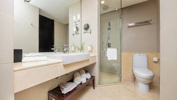 A modern bathroom with a glass-enclosed shower, a white toilet, and a vanity with a mirror.
