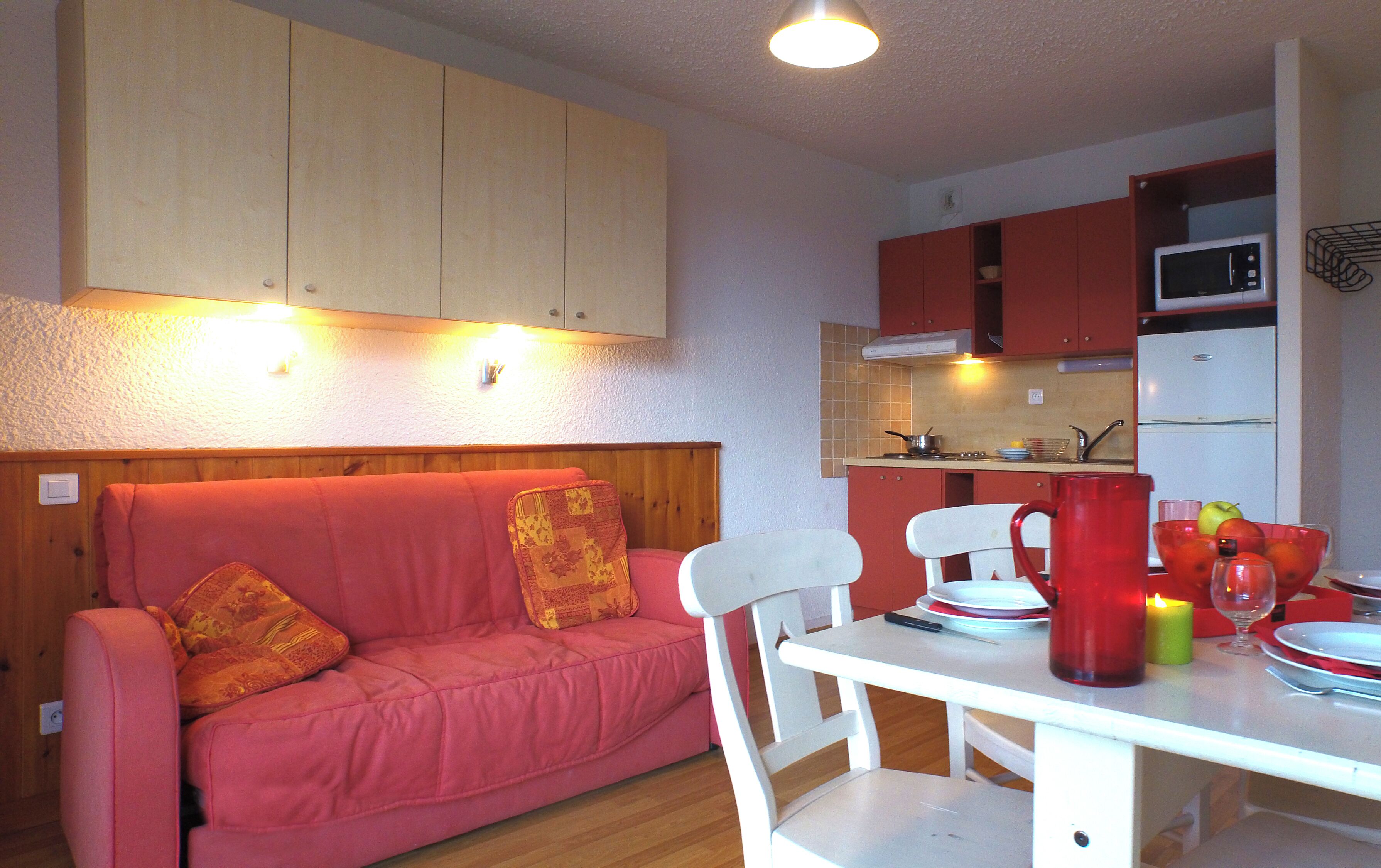 A kitchenette with a microwave, stove, and cabinets.