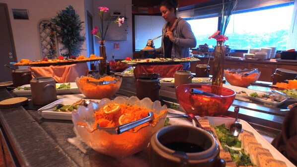 A buffet setup with various food items and serving utensils.