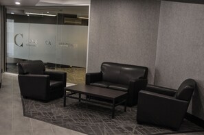 A modern waiting area with a sofa, armchairs, and a coffee table.