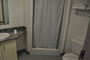 A bathroom with a shower curtain, a sink, a toilet, and a towel rack.