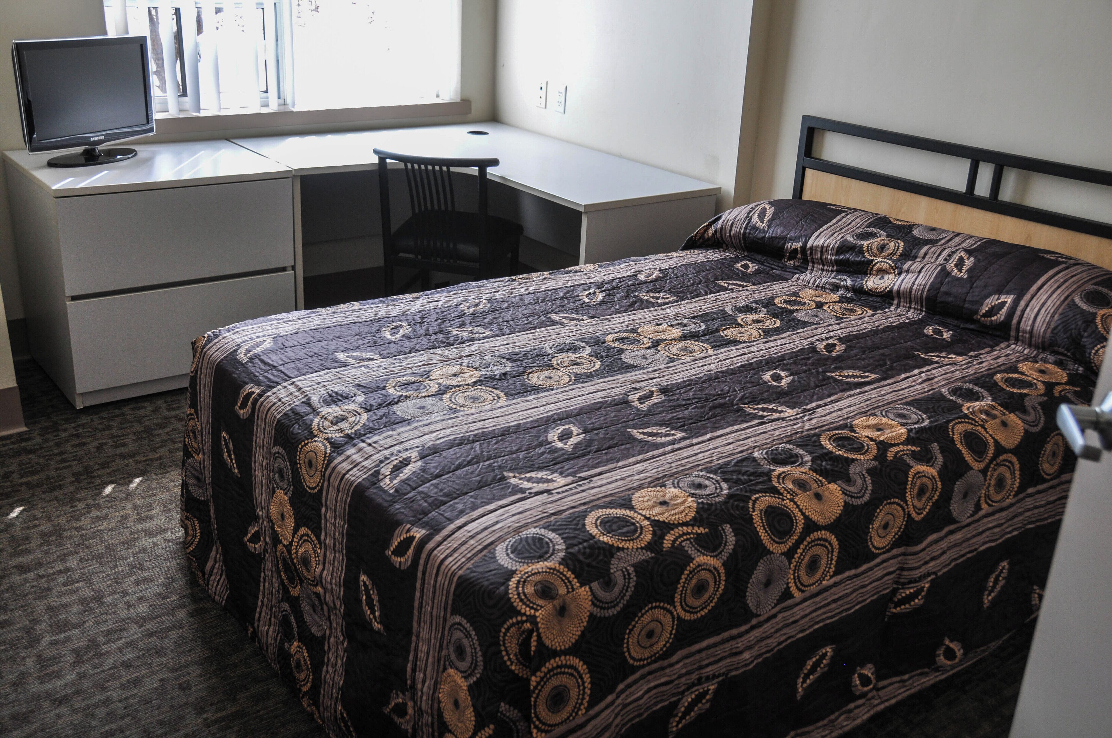 Une chambre à coucher avec un lit, un bureau et une chaise.