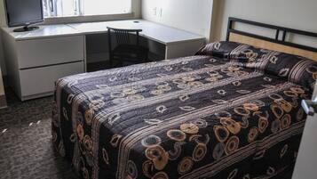 Une chambre à coucher avec un lit, un bureau et une chaise.