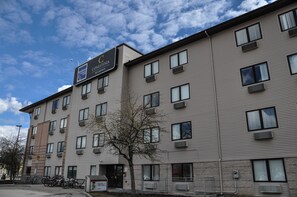 A multi-story residential building with a sign indicating it is a condominium.