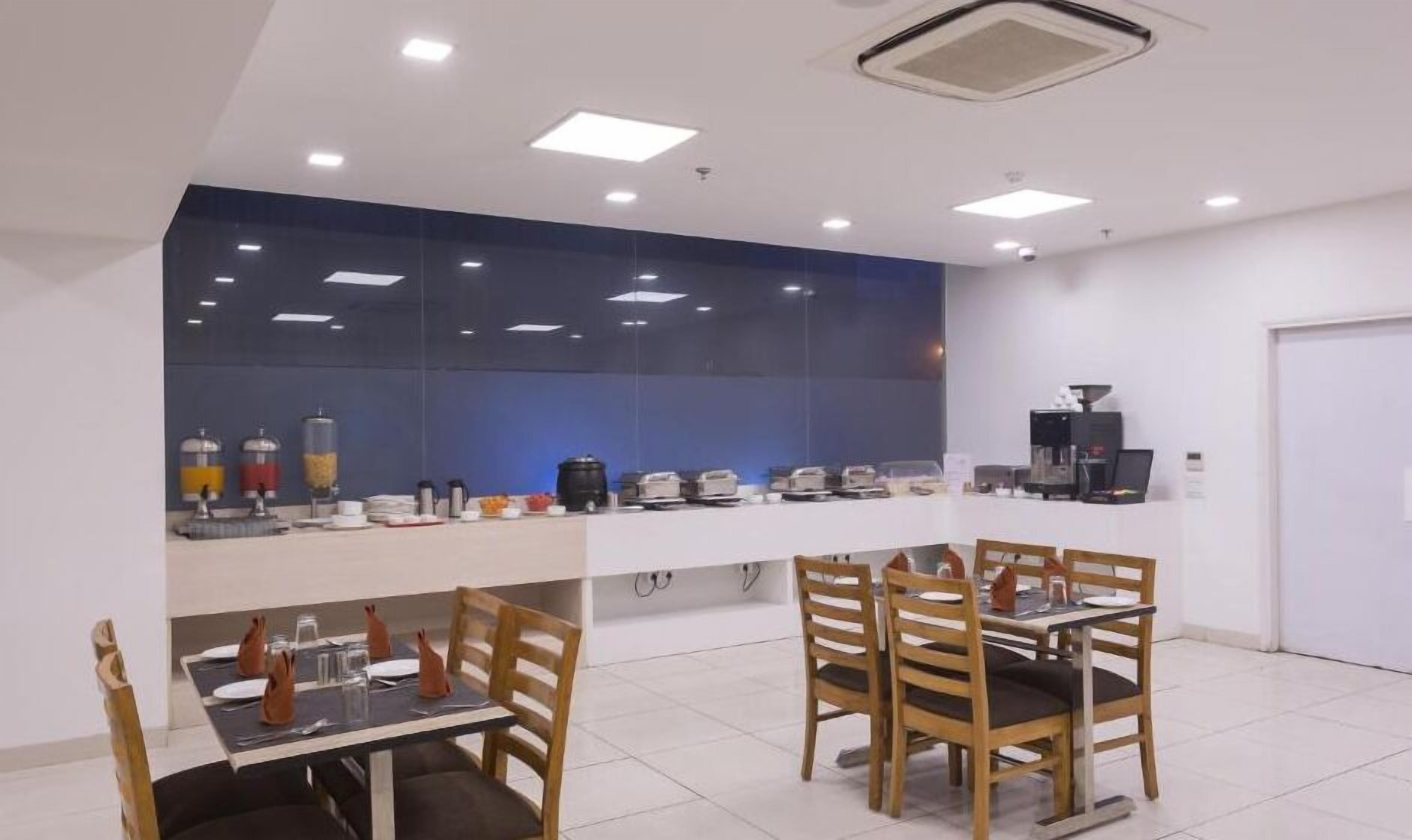 A modern dining area with a long counter, multiple chairs, and a coffee machine.