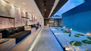 Un interior moderno con una amplia zona de estar, una fuente de agua y vistas al exterior.