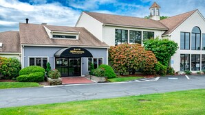 Un edificio de dos plantas con un toldo negro que dice "AllSeasons Resort on Cape Cod".