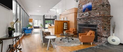 A spacious lobby with a brick fireplace, seating area, and a large window providing natural light.