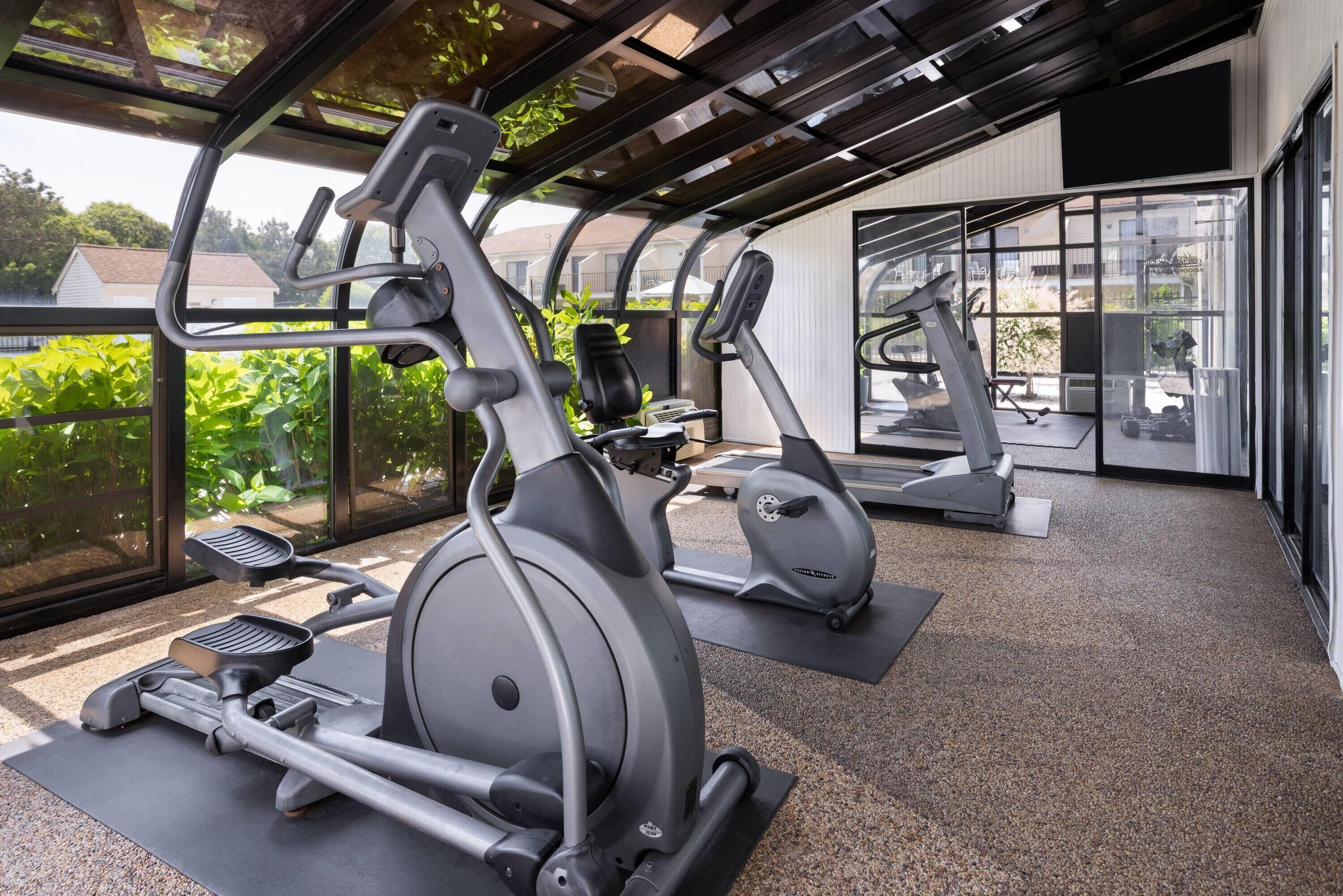 A gym with stationary bikes, treadmills, and elliptical machines.