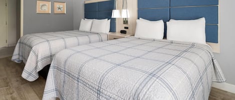Een hotelkamer met twee bedden, een nachtkastje en een lamp aan de muur.