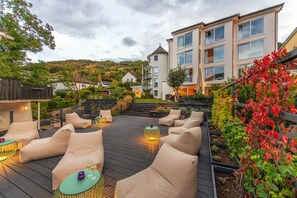 A rooftop patio with outdoor seating and a view of a hillside. - Moselromantik Hotel Kessler Meyer (Cochem)