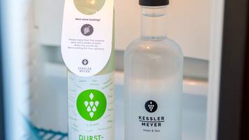 A mini wine tasting setup in a refrigerator with two bottles, one labeled 'Kessler Meyer Hotel & Spa' and the other 'Durst-Löschner.'