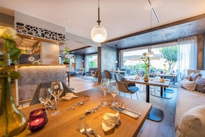 A restaurant with a wooden dining table, chairs, and a large window.