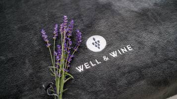 Superficie negra con textura, con las palabras “WELL & WINE” y un logotipo.