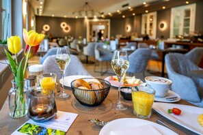 A dining area with tables set for breakfast, including bread, pastries, and beverages. - Moselromantik Hotel Kessler Meyer (Cochem)