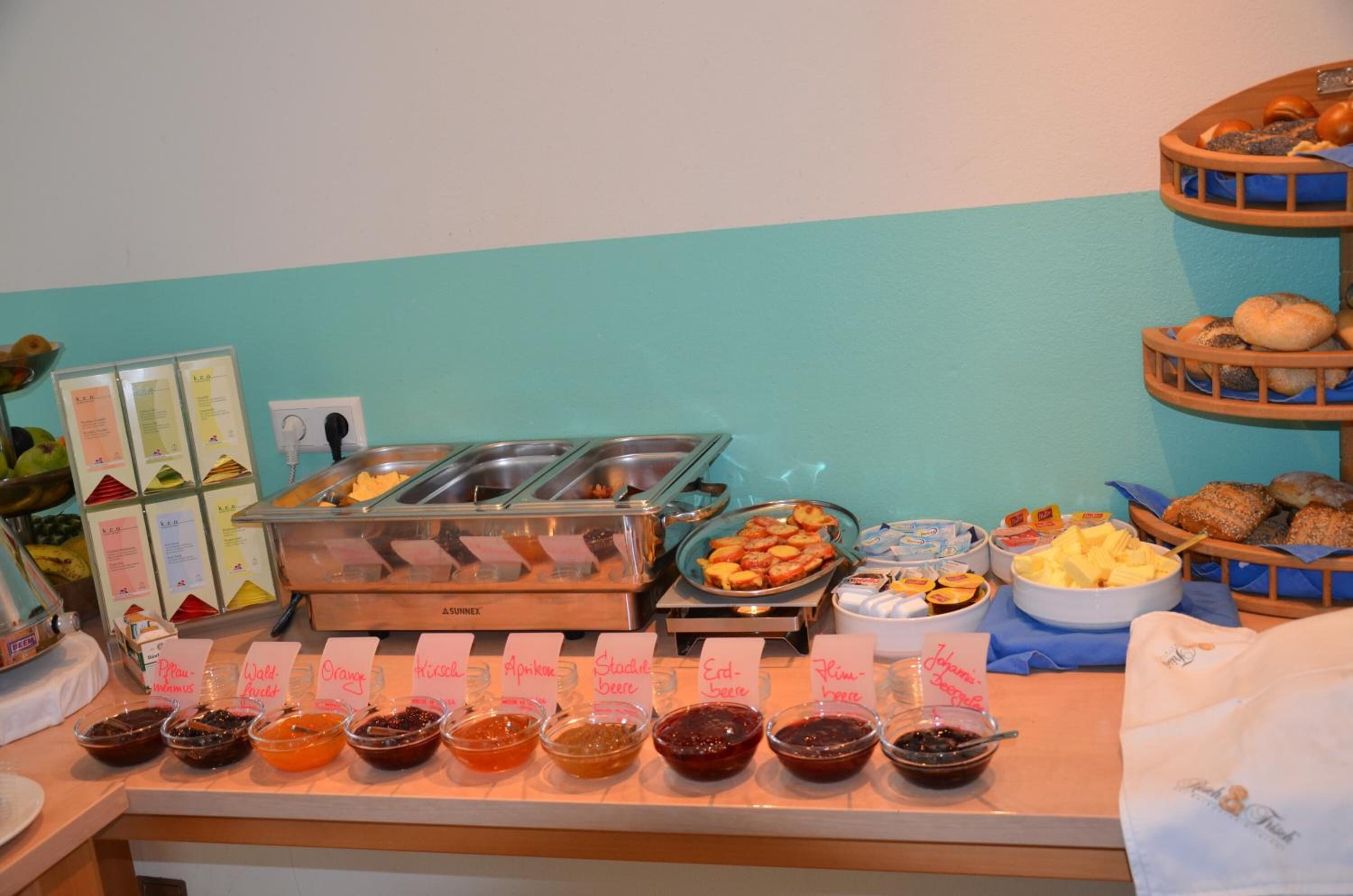 A buffet with various food options including fruits, pastries, and spreads.