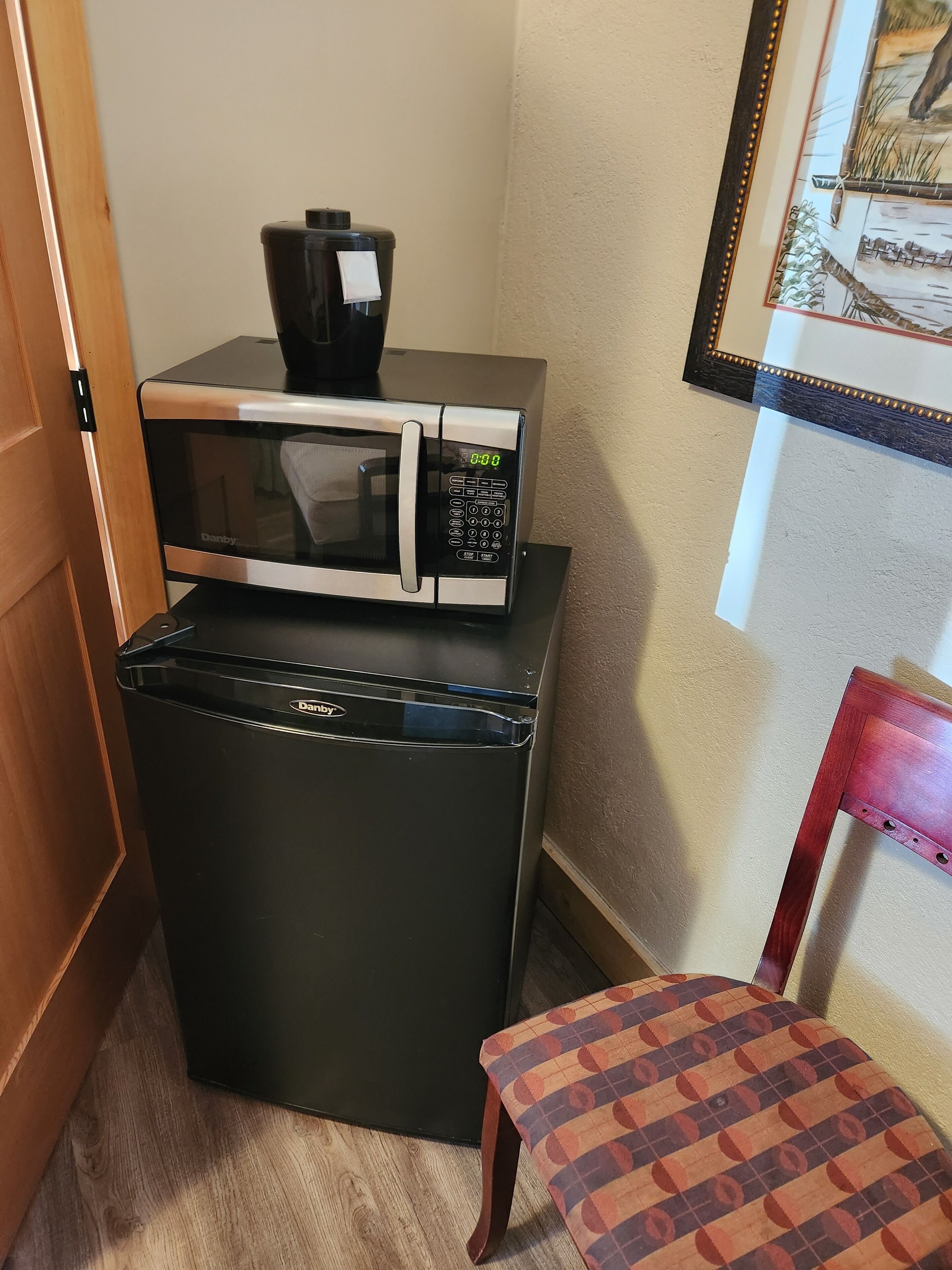 A compact kitchen area with a microwave and a refrigerator.