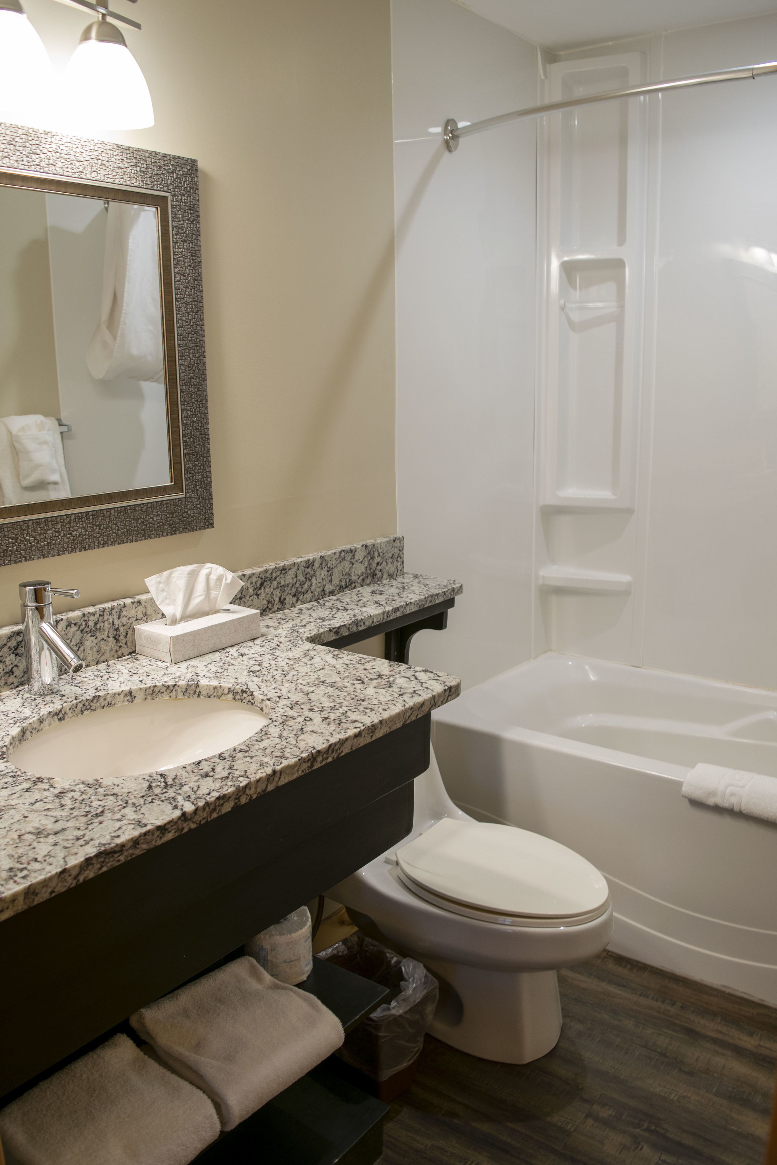 A bathroom with a marble sink, a toilet, and a bathtub.