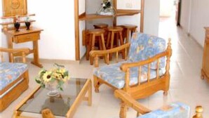 A room with a wooden sofa set, a glass coffee table, and a bookshelf. - Alondras Park Apartamentos (Arona)