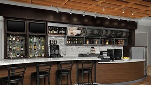 A modern bar area with a curved counter, multiple liquor bottles, and bar stools. - Courtyard Phoenix Chandler/Fashion Center (Chandler)