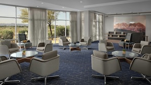 A modern hotel lobby with a geometric patterned carpet, round tables, and comfortable seating. - Courtyard Phoenix Chandler/Fashion Center (Chandler)