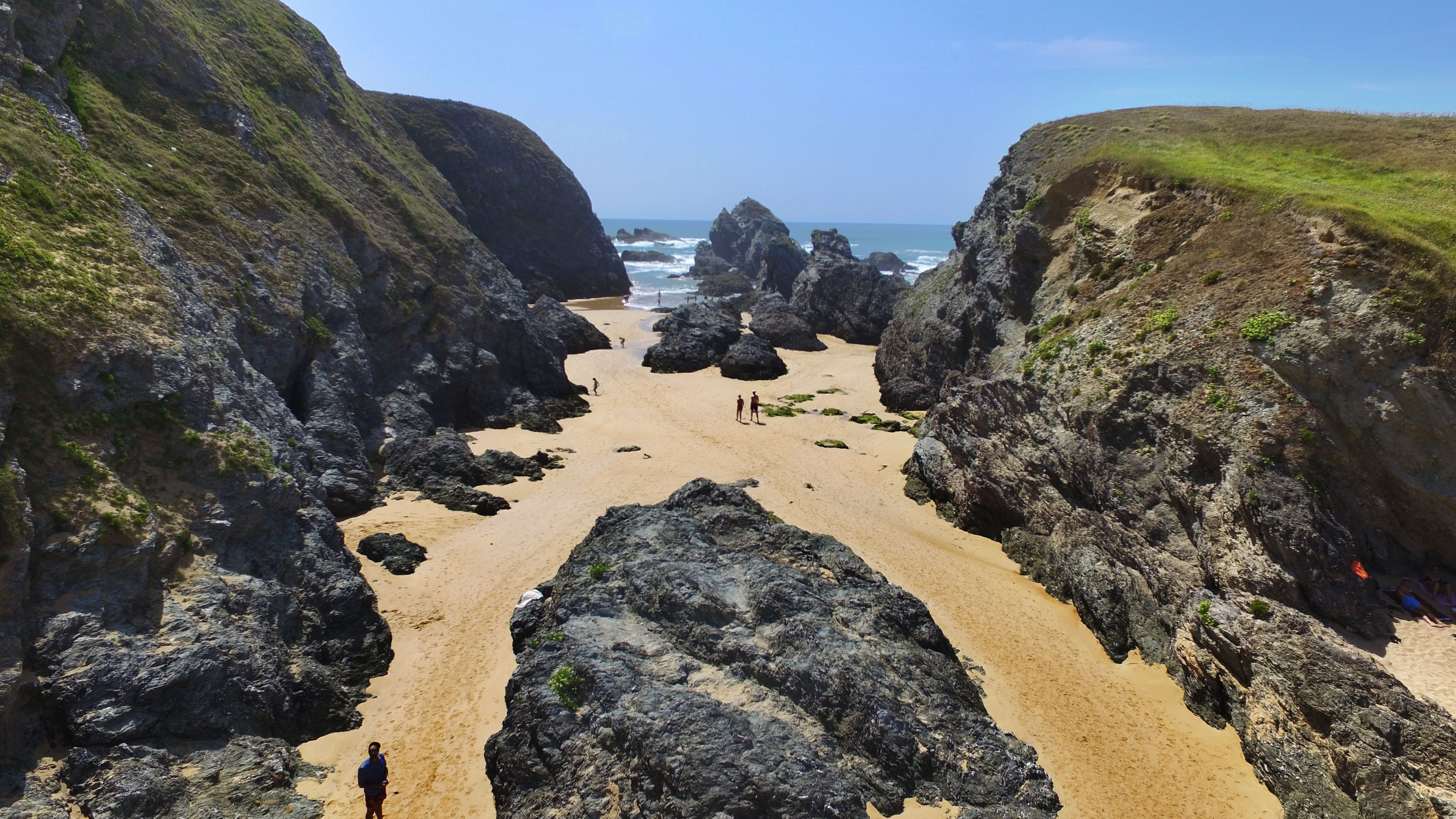A beach with rocky formations and a clear view of the ocean.