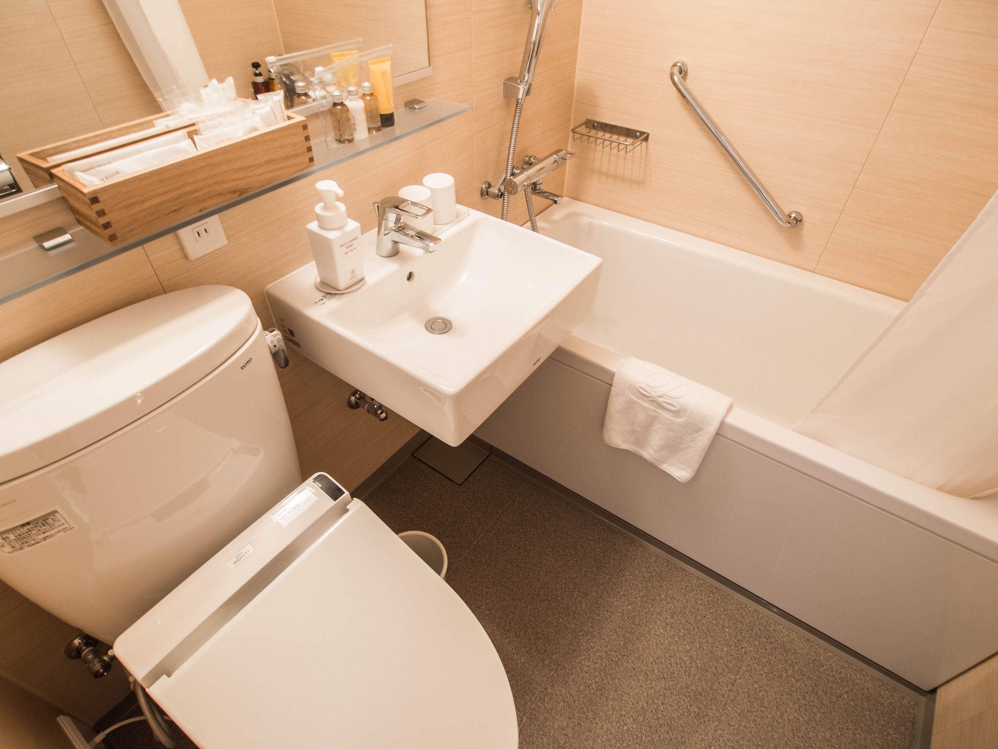 Une salle de bain moderne équipée de toilettes, d’un lavabo et d’une baignoire.