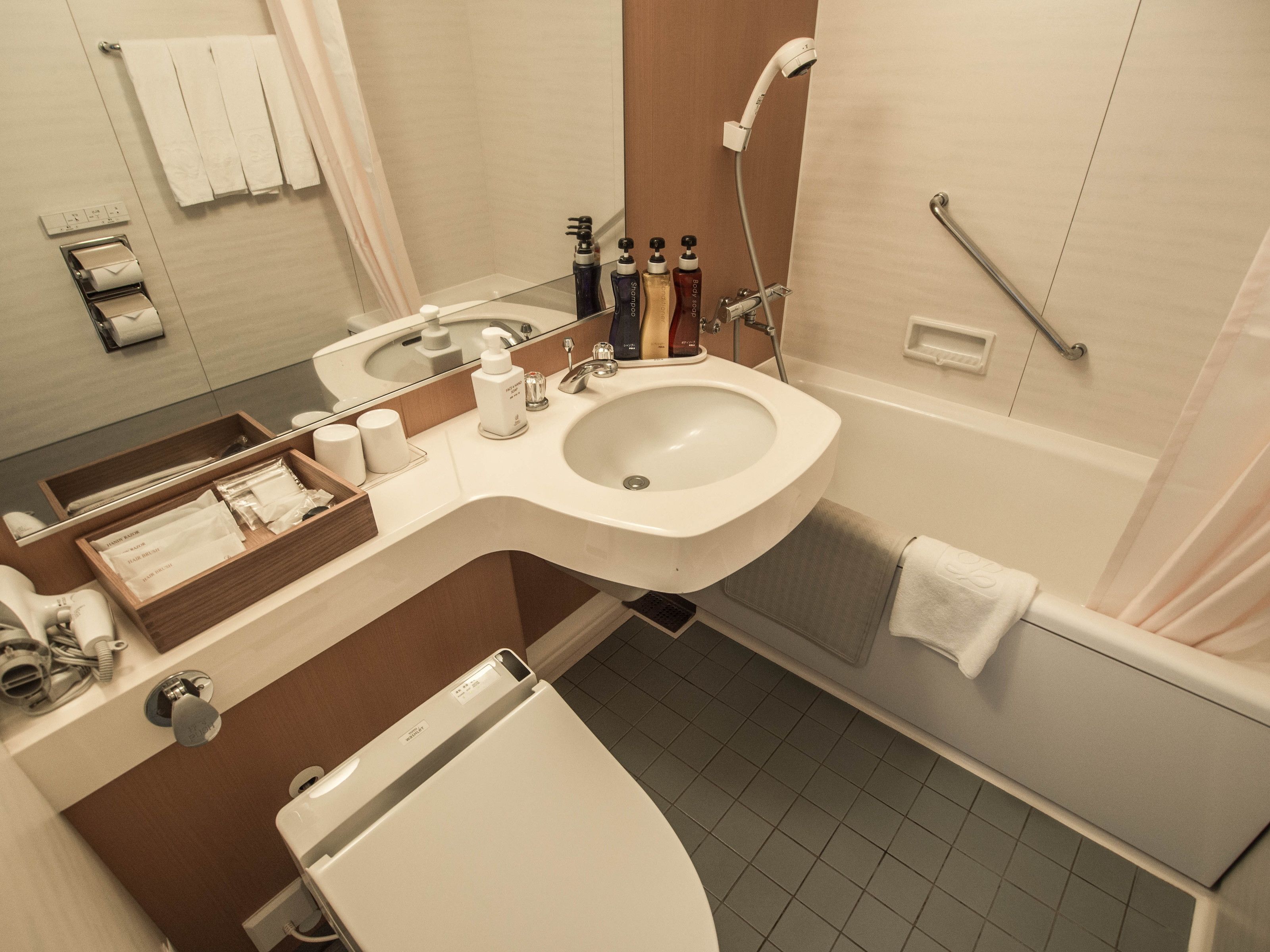 Ein modernes Badezimmer mit Waschbecken, Spiegel und Dusche.