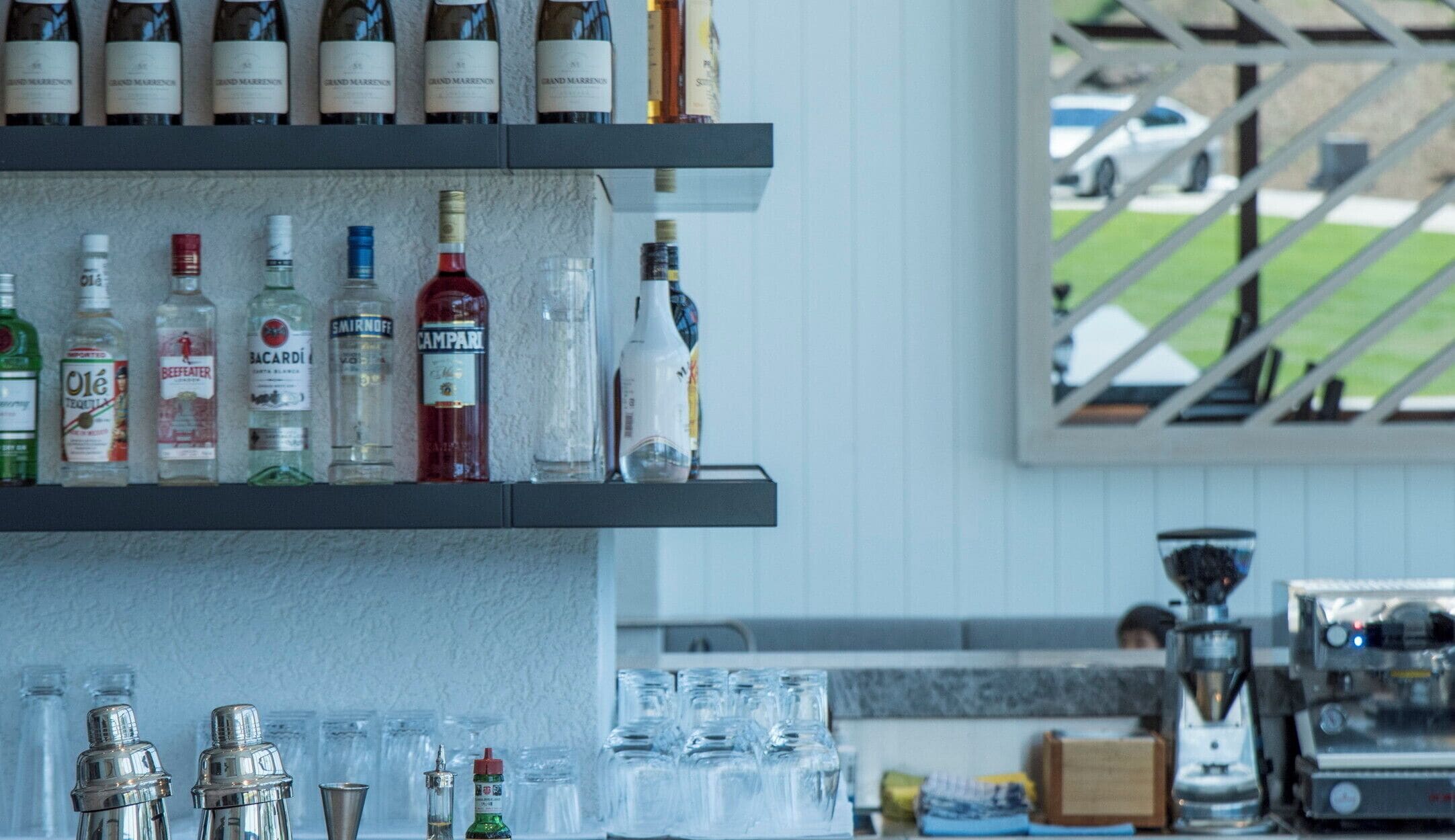 A bar area with shelves of liquor bottles and glasses.