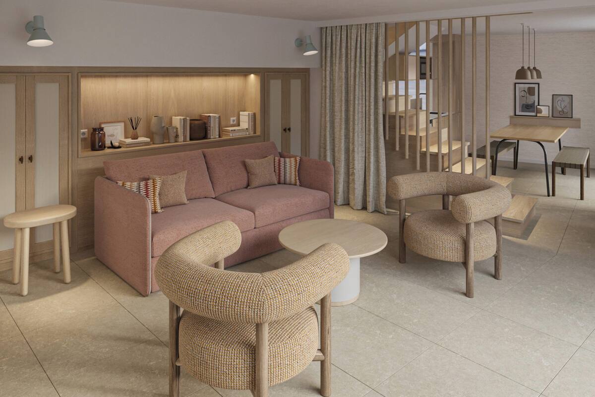 Ein modernes Wohnzimmer mit einer Couch, zwei Sesseln, einem Couchtisch, einer Essecke mit Tisch und Stühlen sowie einer Treppe.